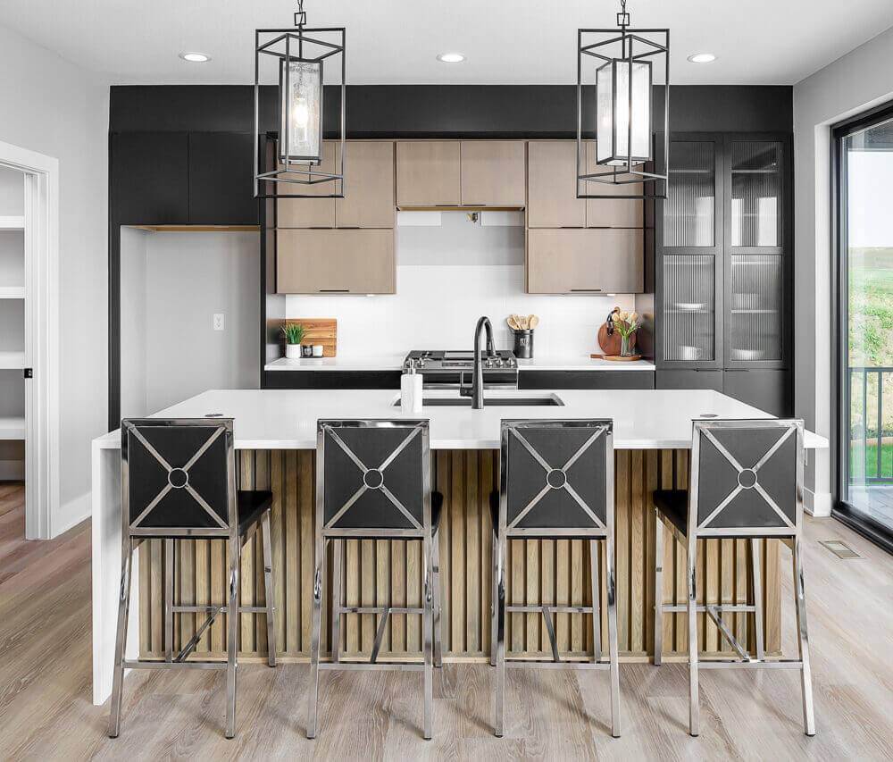 A kitchen island with decorative wood paneling and artistically designed stools for seating