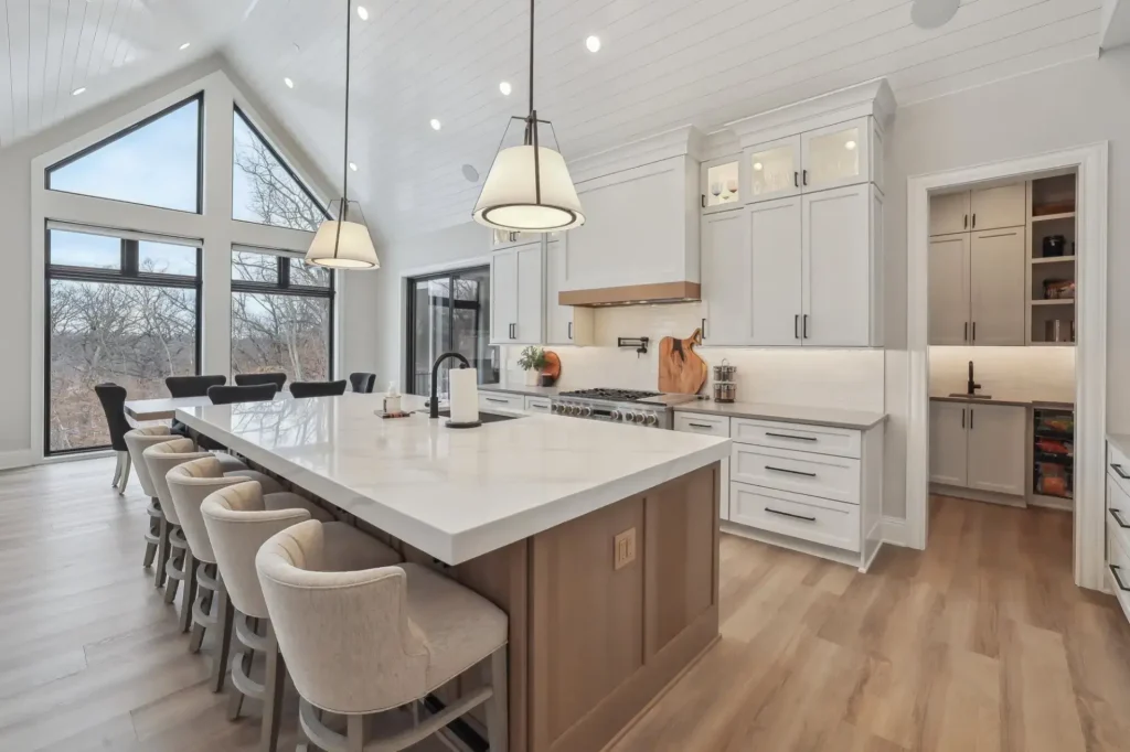 A large kitchen with a butler's pantry that features cabinets, shelving, and a sink