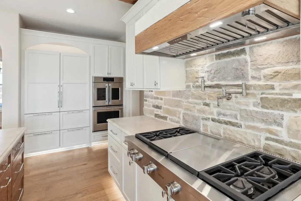 A kitchen with an over-the-stove pot filler above the oven and range